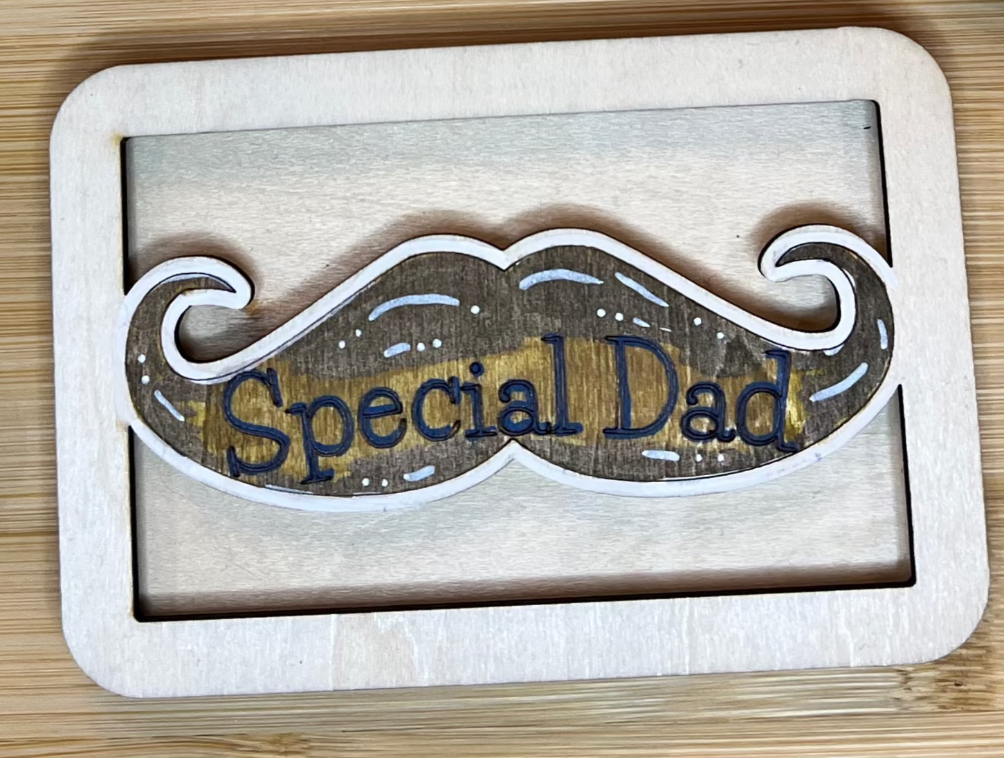 Wooden sign with 'Special Dad' text and decorative border on a wooden surface